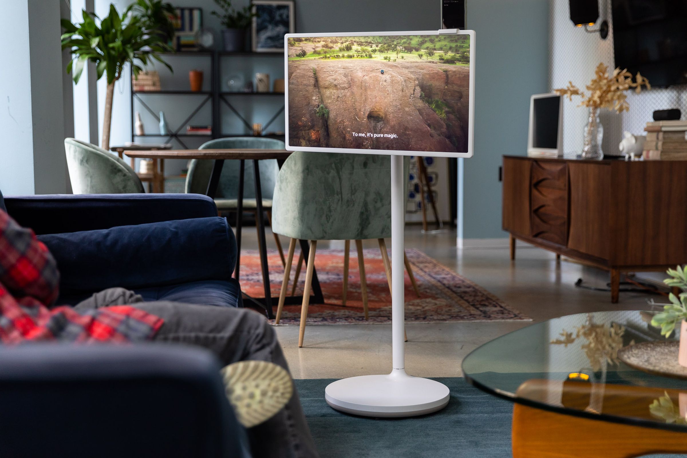 The LG StanbyME display next to a blue couch in a living room setting.